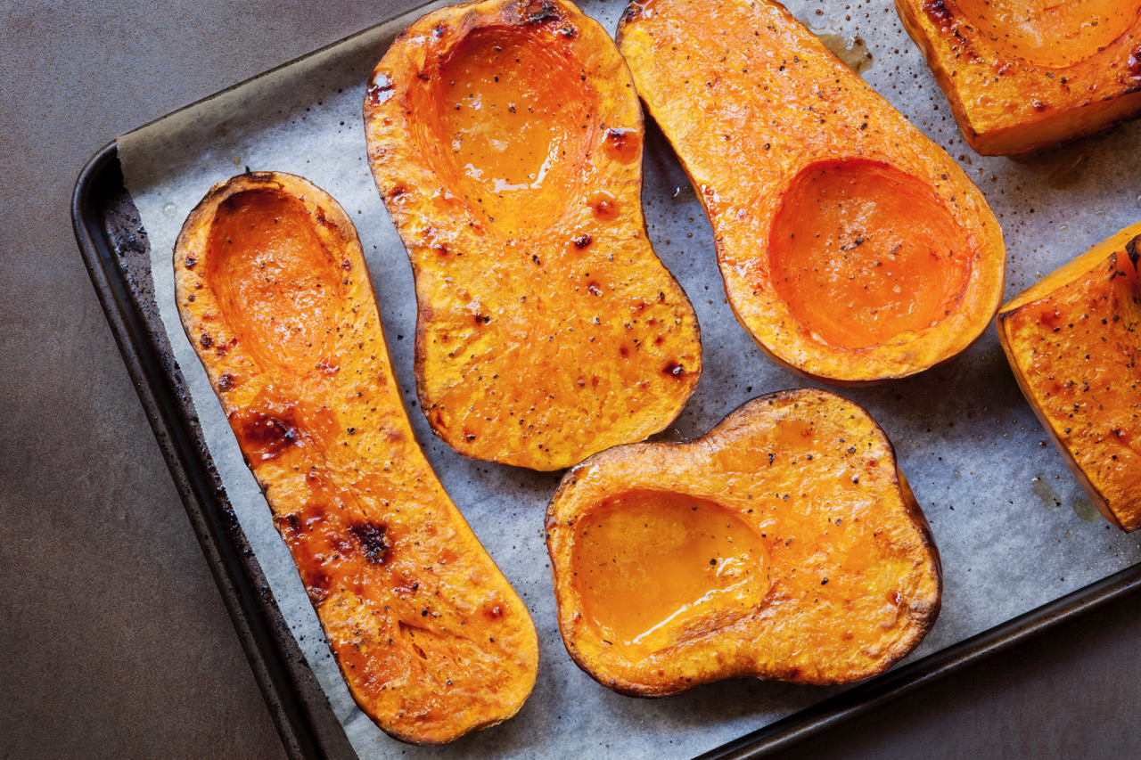 Roasting butternut pumpkin, for a warming soup. Top view on oven tray.